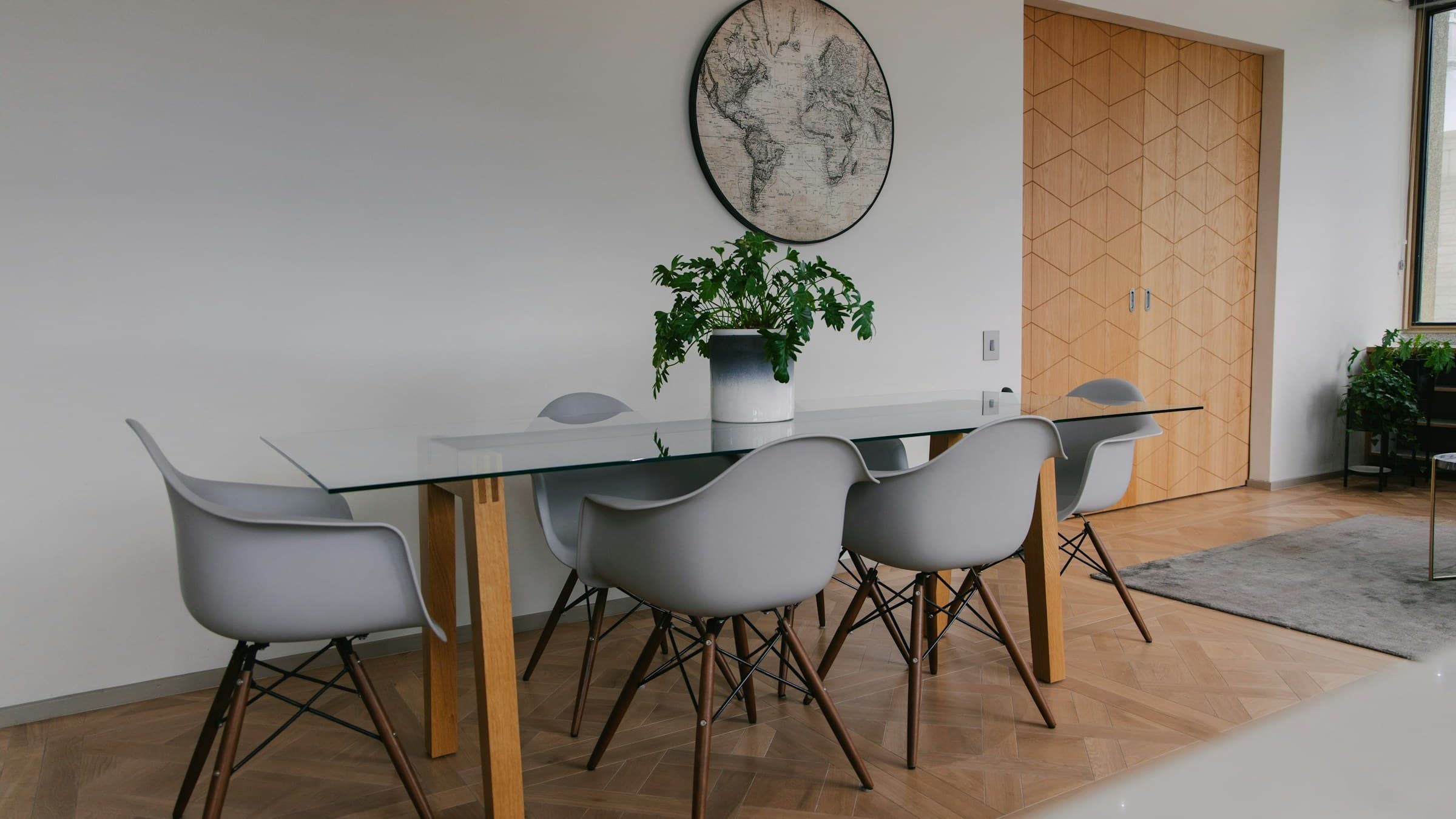 Skleněný jídelní stůl s dubovými nohami a designovými židlemi